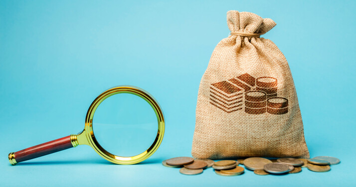 Money bag with magnifying bag on blue background. concept of finding or investing funders
